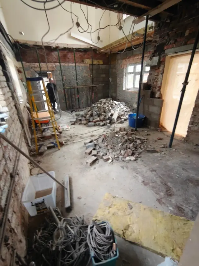 Building work in progress at a separate Chorlton project, with exposed brickwork and temporary props